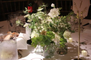 Vases of white flowers on table at Elisabeth and Ben's wedding.